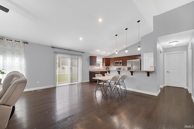 dining space with dark wood-type flooring and high vaulted ceiling