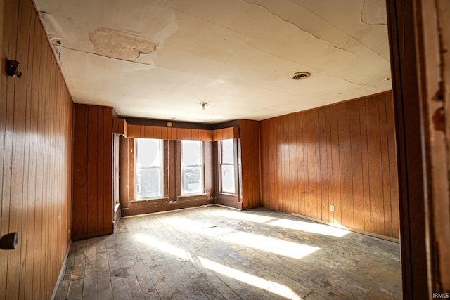 unfurnished room featuring wooden walls and light wood-type flooring