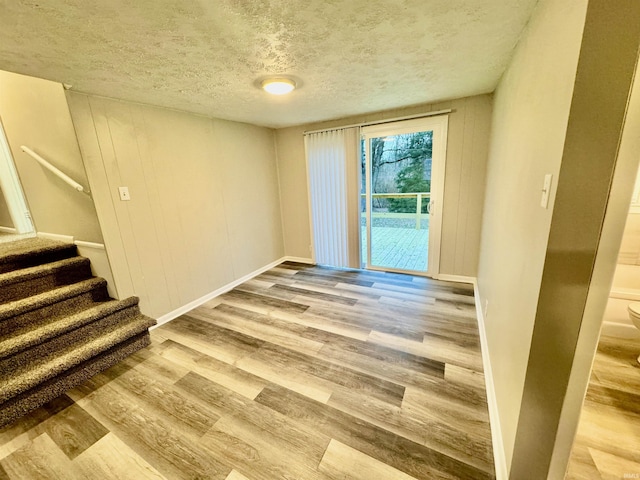 unfurnished room with hardwood / wood-style flooring and a textured ceiling