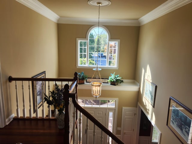 stairway with crown molding and a notable chandelier