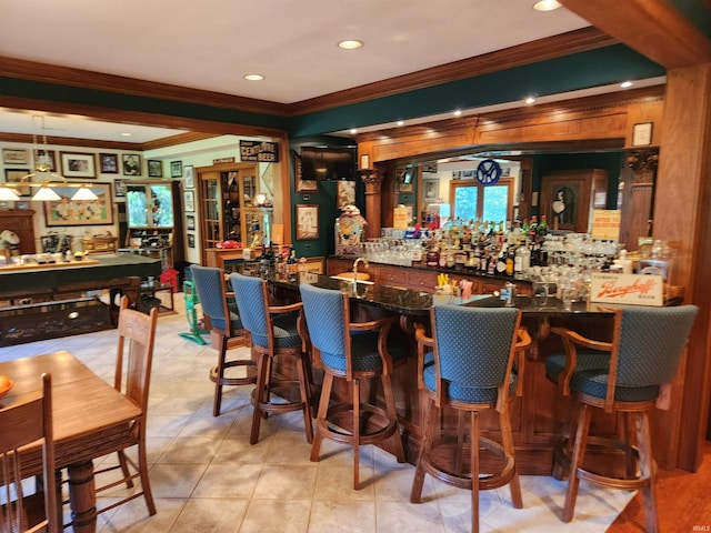 bar with ornamental molding and light tile patterned floors