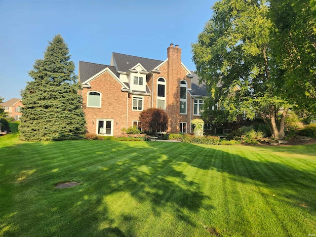 rear view of property with a lawn