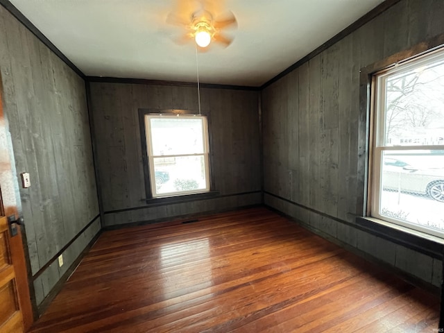 unfurnished room featuring dark wood-type flooring and wooden walls