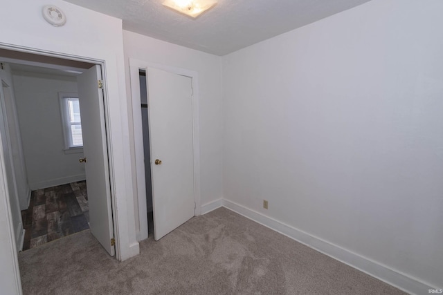 spare room featuring dark colored carpet