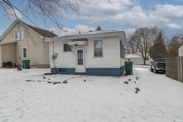 view of snow covered back of property