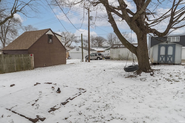 yard covered in snow with a storage unit