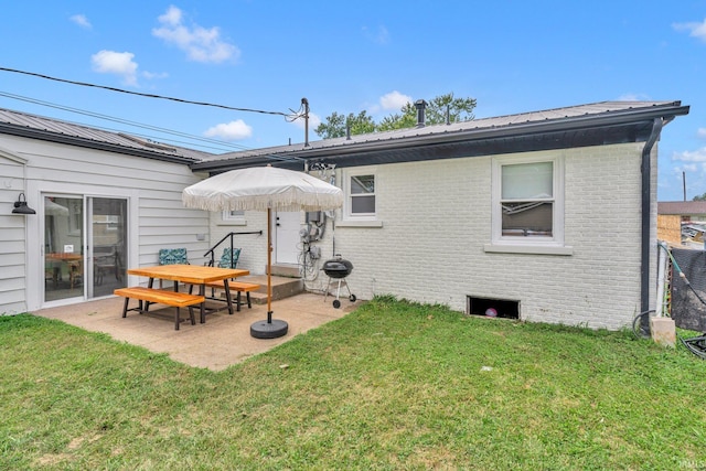 back of house with a patio and a lawn