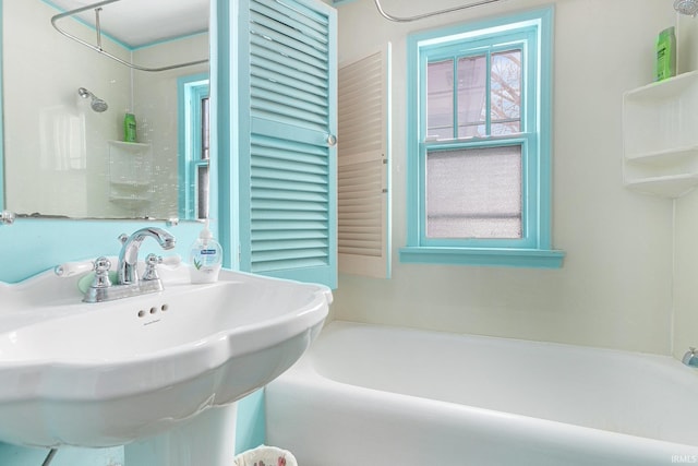 bathroom with bathing tub / shower combination and sink