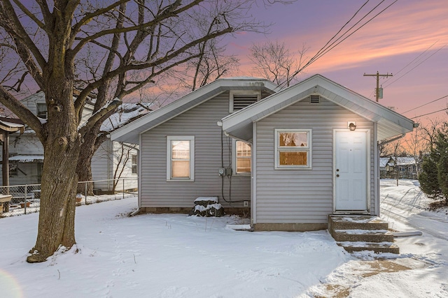 snow covered back of property with entry steps