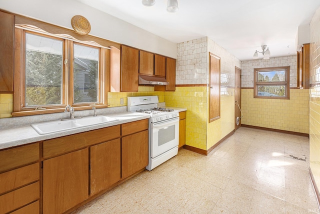 kitchen with tile walls, sink, and gas range gas stove