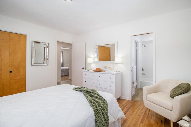 bedroom with light hardwood / wood-style floors, a closet, and ensuite bathroom