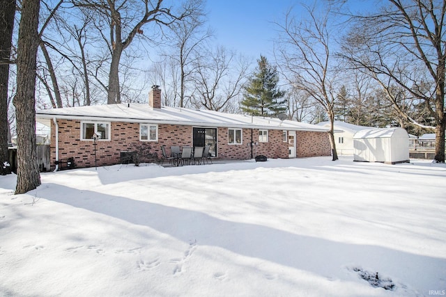 snow covered house with a storage unit