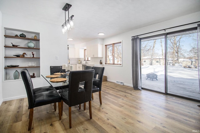 dining space with sink and light hardwood / wood-style floors