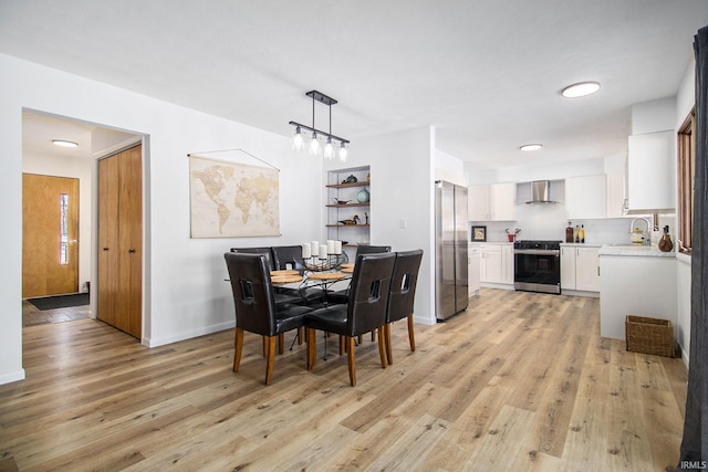 dining space featuring sink and light wood-type flooring