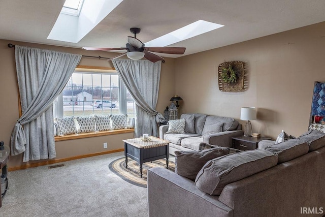 carpeted living room featuring a skylight and ceiling fan