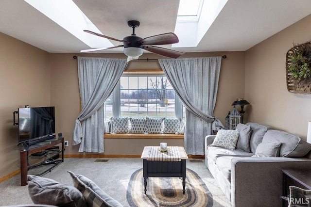 living room featuring ceiling fan, a skylight, and carpet