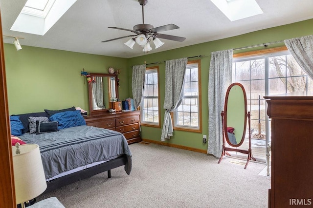 bedroom with light carpet, ceiling fan, and a skylight