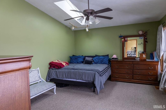 carpeted bedroom featuring lofted ceiling with skylight and ceiling fan