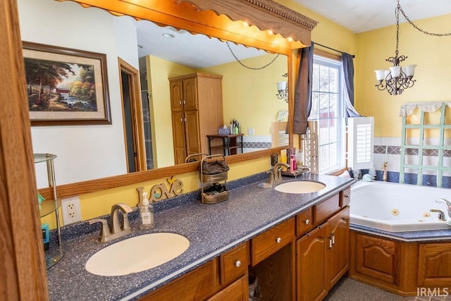 bathroom featuring vanity, a notable chandelier, and a bathing tub