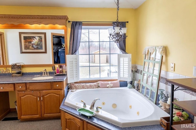 bathroom featuring vanity, a tub, and a chandelier