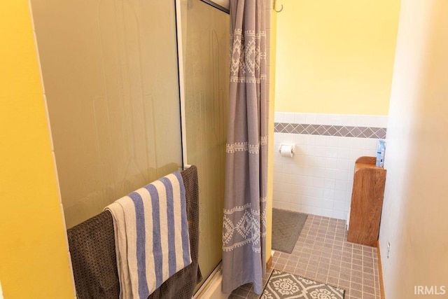 bathroom with a shower and tile walls