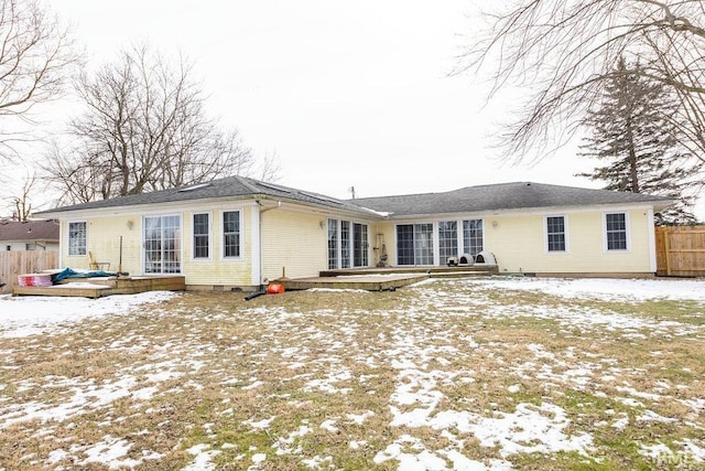 snow covered house featuring a wooden deck