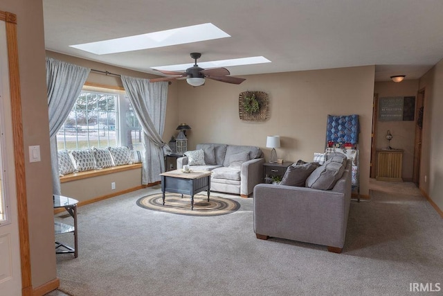 living room with ceiling fan, a skylight, and carpet floors