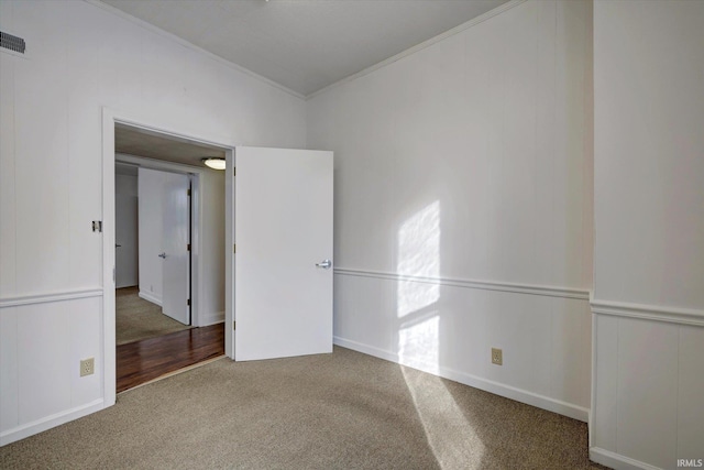 unfurnished room with ornamental molding and carpet flooring