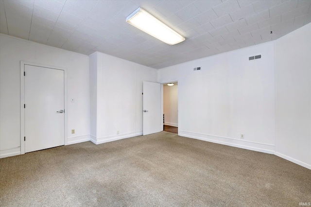 spare room with ornamental molding and carpet flooring