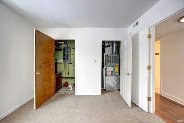 carpeted bedroom with electric panel and heating unit