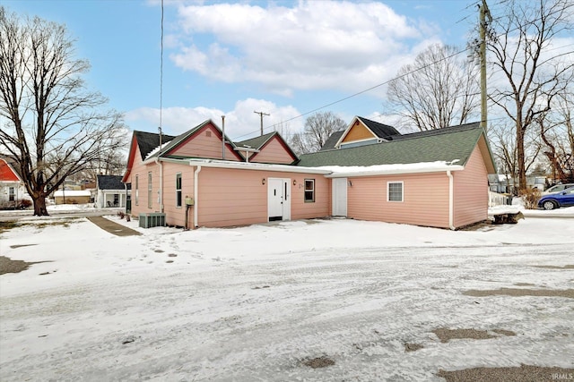 snow covered rear of property with central air condition unit