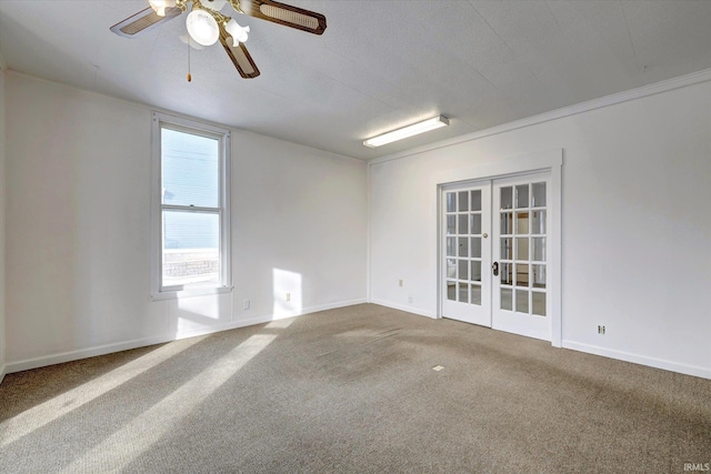 carpeted spare room with french doors, ceiling fan, and ornamental molding