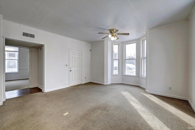 carpeted spare room featuring ceiling fan and a healthy amount of sunlight