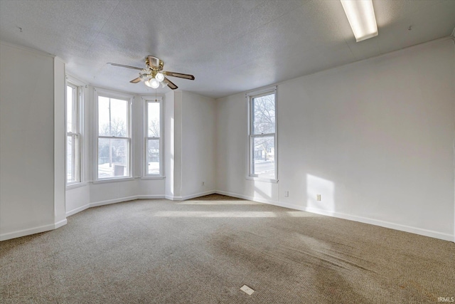 carpeted empty room with ceiling fan and a textured ceiling