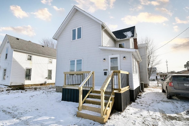 view of snow covered rear of property