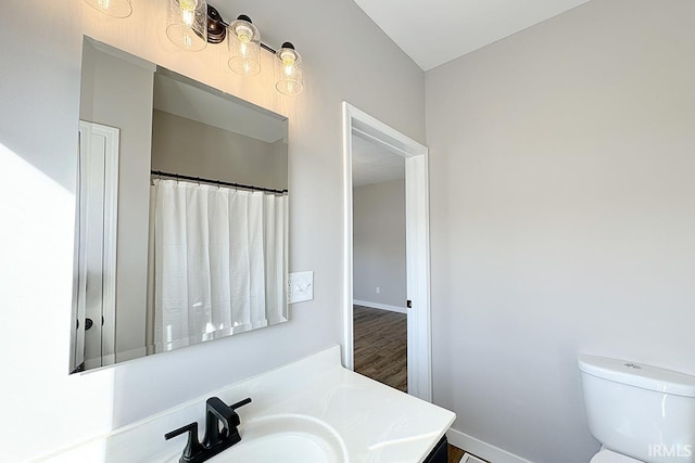 bathroom featuring vanity, toilet, and hardwood / wood-style floors