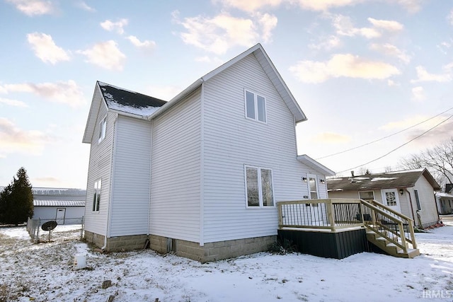 snow covered property featuring a deck