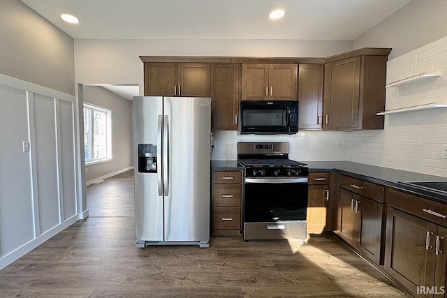 kitchen featuring dark wood-type flooring, stainless steel appliances, dark brown cabinets, and backsplash