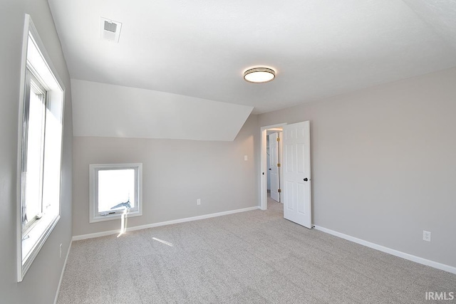 additional living space with light colored carpet and lofted ceiling