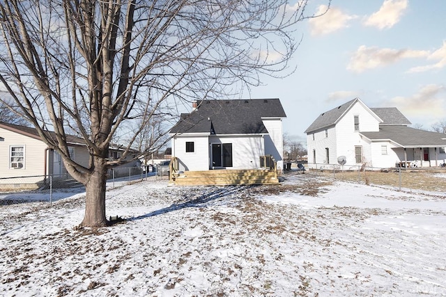 view of snow covered back of property