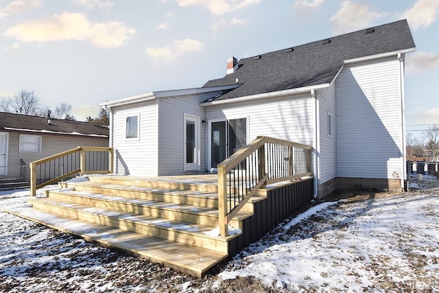 snow covered rear of property featuring a deck