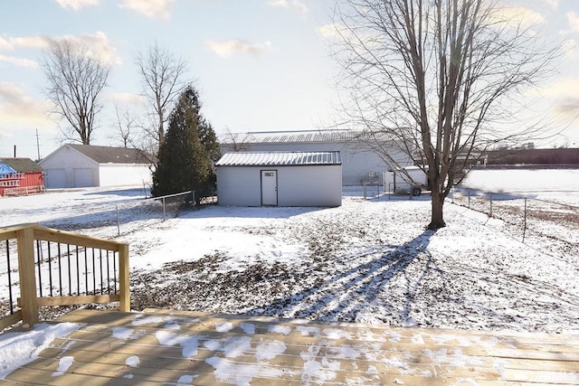 yard covered in snow featuring a garage and a storage shed