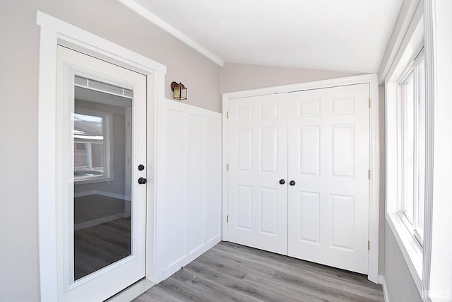 interior space featuring lofted ceiling and light hardwood / wood-style flooring