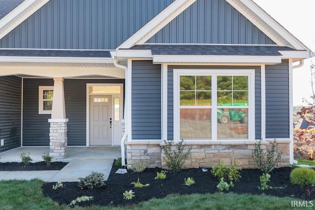 view of exterior entry featuring covered porch