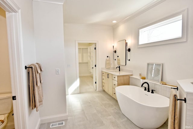 bathroom featuring tile patterned flooring, a tub to relax in, vanity, and crown molding