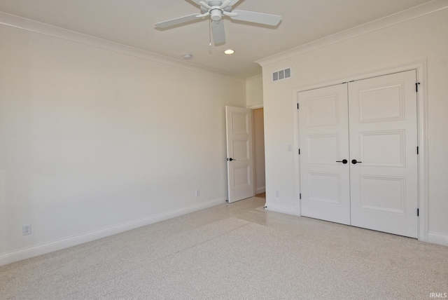 unfurnished bedroom with ornamental molding, a closet, and ceiling fan