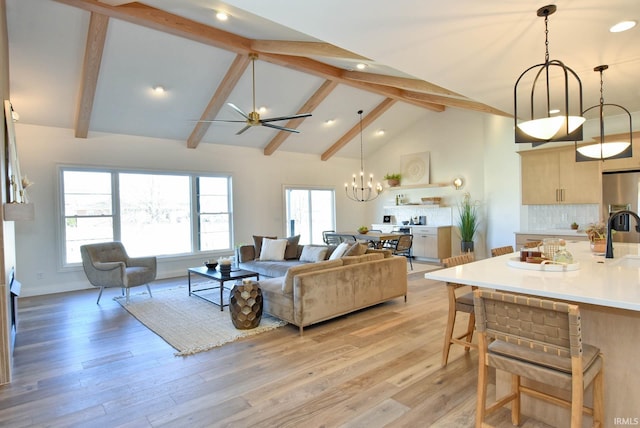 living room featuring ceiling fan with notable chandelier, high vaulted ceiling, beamed ceiling, and light wood-type flooring