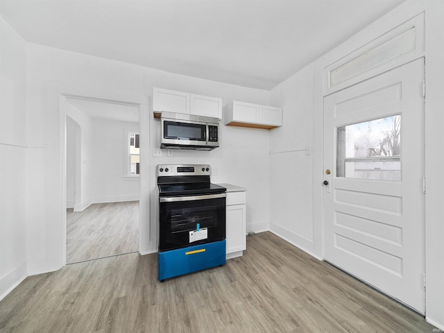 kitchen featuring range with electric stovetop, light hardwood / wood-style floors, and white cabinets