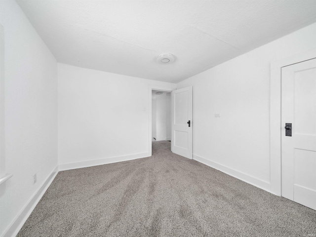 carpeted empty room featuring a textured ceiling