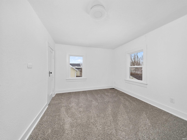 carpeted spare room featuring a healthy amount of sunlight